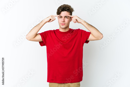 Young caucasian man isolated on white background focused on a task, keeping forefingers pointing head.