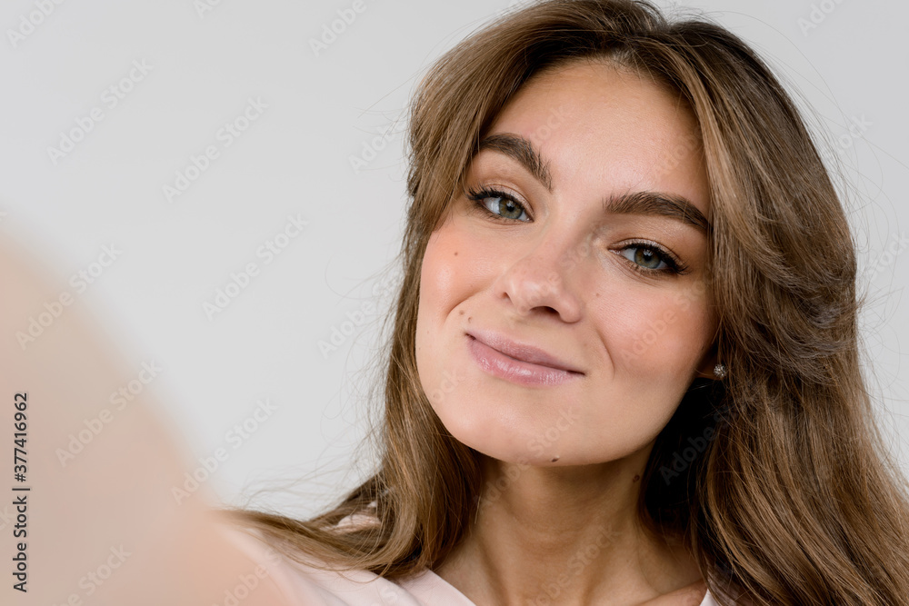 Taking picture. Smiling cheerful woman doing selfie on isolated white background Taking picture. Smiling cheerful woman doing selfie on isolated white background