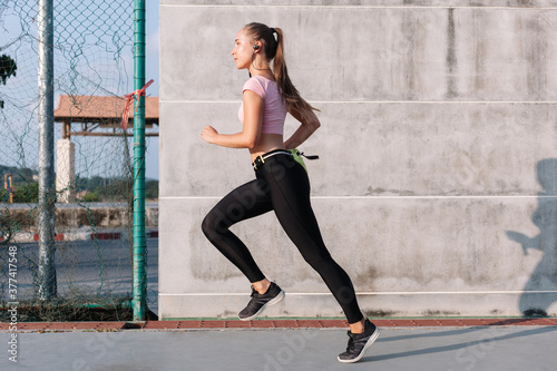 Summer sport street style portrait of young beautiful runner athlete woman