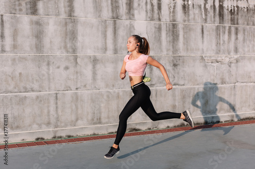 Summer sport street style portrait of young beautiful runner athlete woman