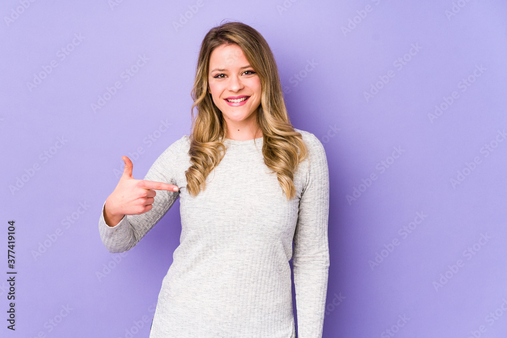Young caucasian woman isolated on purple background person pointing by hand to a shirt copy space, proud and confident Young caucasian woman isolated on purple background person pointing by hand to a shirt copy space, proud and confident