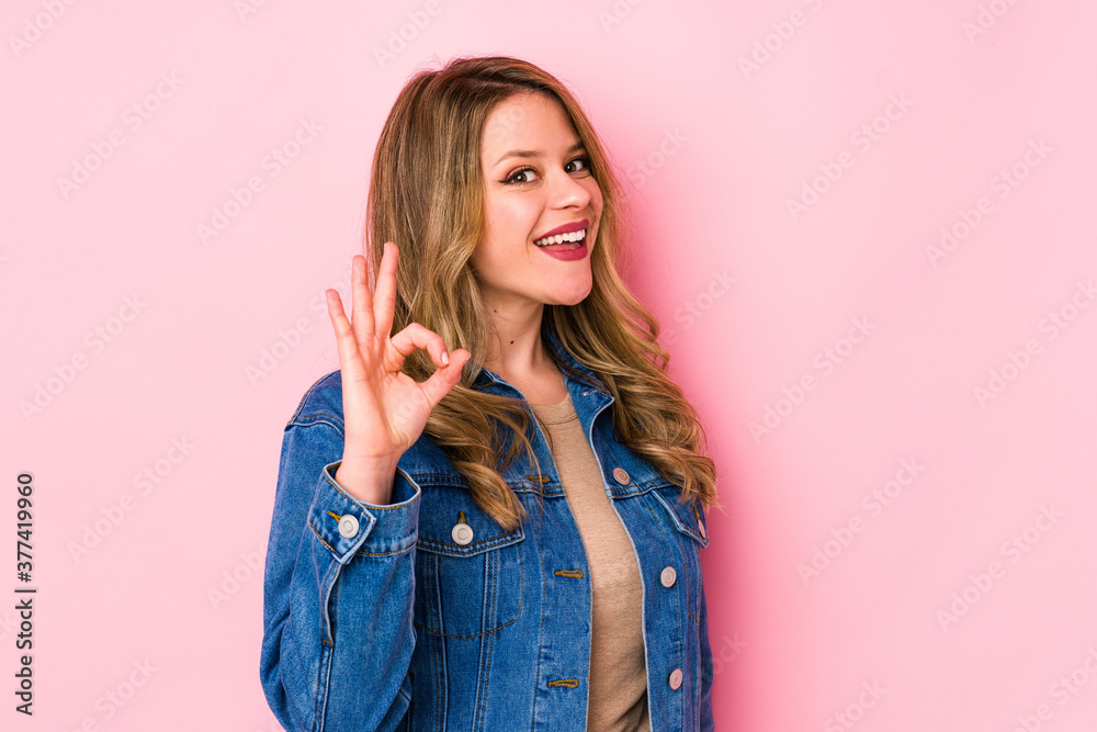 Young caucasian woman isolated on pink background cheerful and confident showing ok gesture. Young caucasian woman isolated on pink background cheerful and confident showing ok gesture.