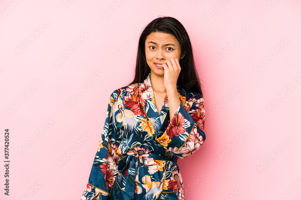 Young chinese woman wearing a asiatic pijama isolated shouting and holding palm near opened mouth. Young chinese woman wearing a asiatic pijama isolated shouting and holding palm near opened mouth.