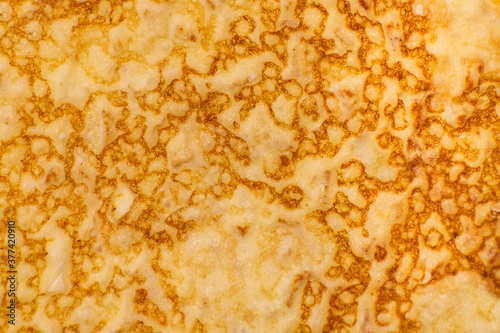 Texture of a cooked thin pancake closeup, food background