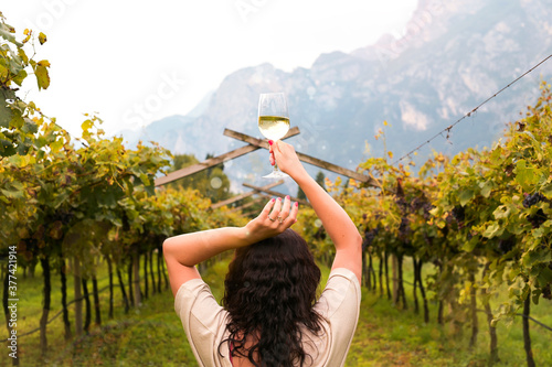 Young woman with a glass of white wine in the vineyards of Italy. Person pouring wine. Free space for text. High quality photo photo