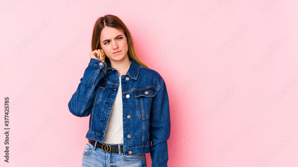 Young caucasian woman isolated on pink background covering ears with fingers, stressed and desperate by a loudly ambient. Young caucasian woman isolated on pink background covering ears with fingers, stressed and desperate by a loudly ambient.