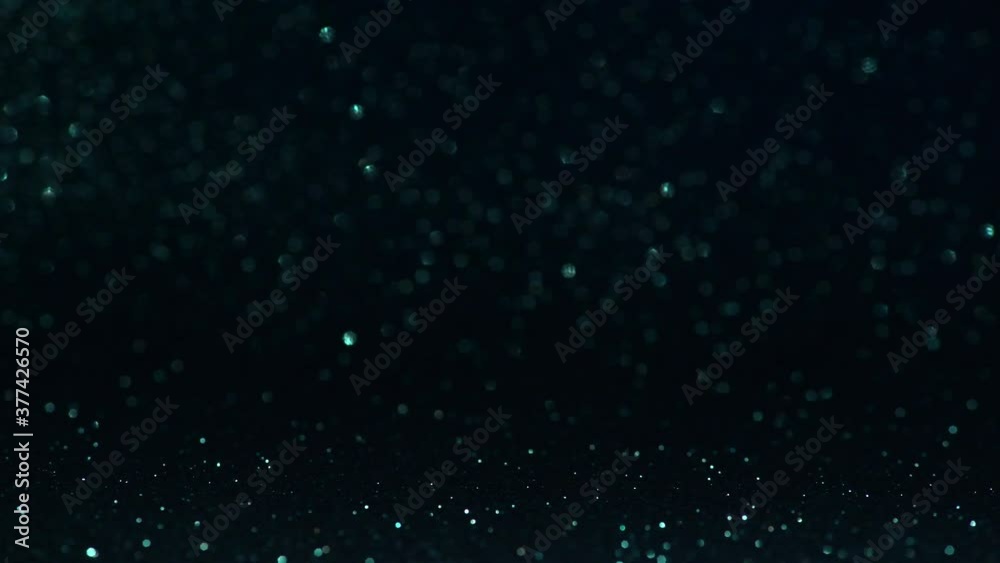 Blue dark glitter background with in focus and out of focus area and reflections in the bokeh with movement Blue dark glitter background with in focus and out of focus area and reflections in the bokeh with movement