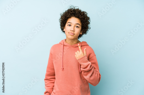 African american little boy isolated pointing with finger at you as if inviting come closer.