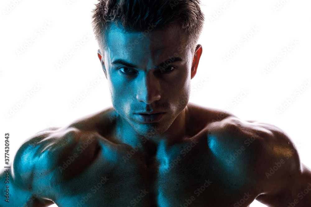 Muscular model sports young man on white background. Fashion portrait of strong brutal guy. Male flexing his muscles. Muscular model sports young man on white background. Fashion portrait of strong brutal guy. Male flexing his muscles.
