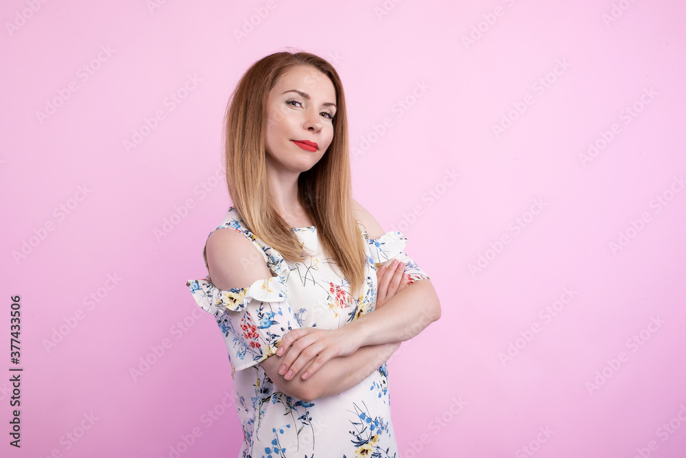 Waist up portrait of beautiful European 20 y.o. woman with freckles and hair knot posing isolated against grey studio wall background with copy space for your text, having calm expression on her face Waist up portrait of beautiful European 20 y.o. woman with freckles and hair knot posing isolated against grey studio wall background with copy space for your text, having calm expression on her face