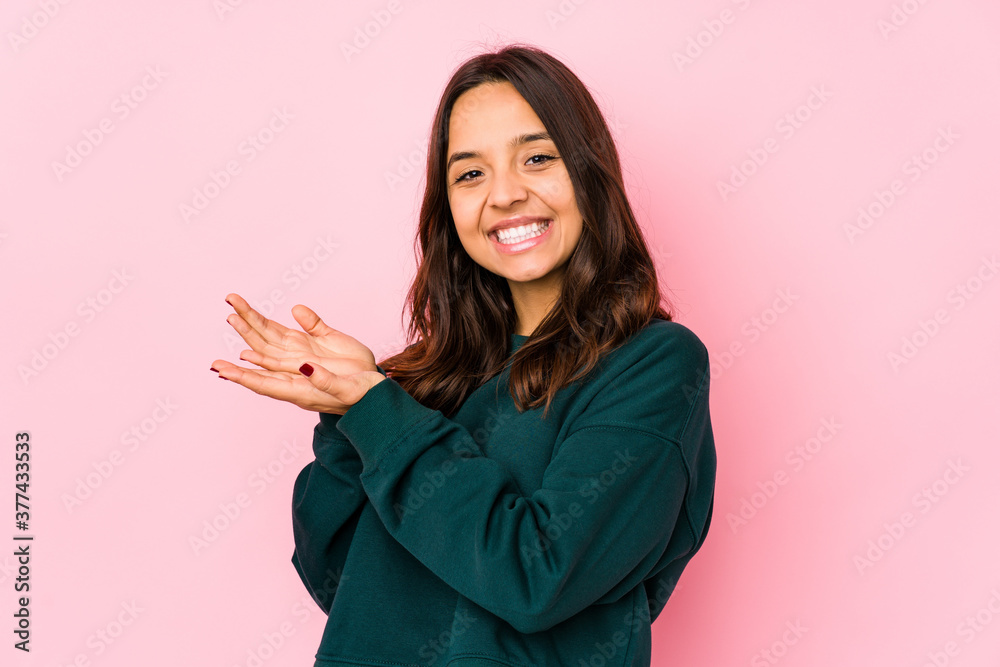 Young mixed race hispanic woman isolated holding a copy space on a palm. Young mixed race hispanic woman isolated holding a copy space on a palm.