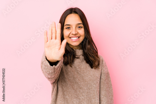 Young mixed race hispanic woman isolated smiling cheerful showing number five with fingers.