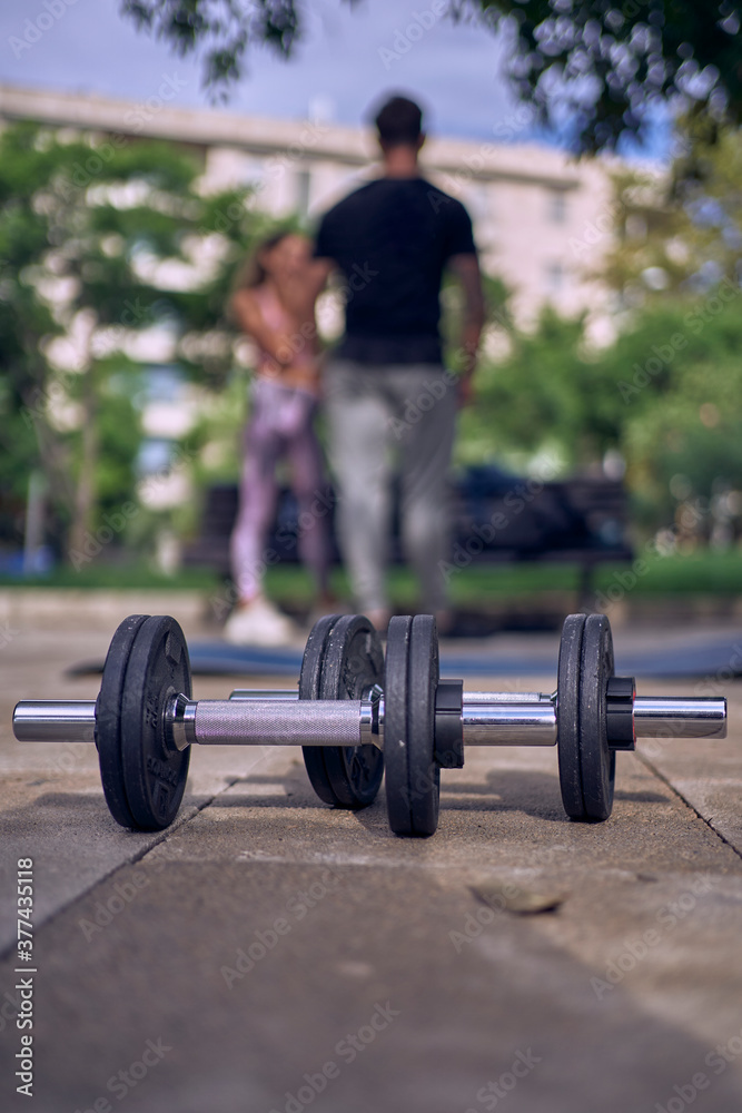 Fitness woman with personal trainer doing exercises on mat outdoors Fitness woman with personal trainer doing exercises on mat outdoors