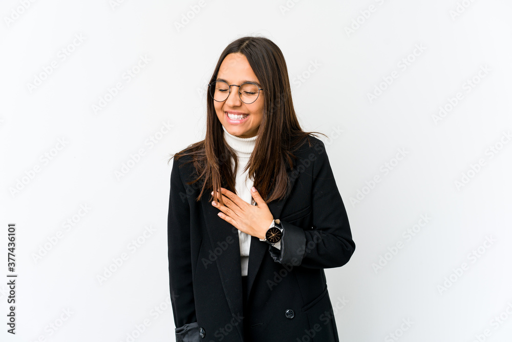 Young mixed race business woman isolated on white background laughing keeping hands on heart, concept of happiness. Young mixed race business woman isolated on white background laughing keeping hands on heart, concept of happiness.