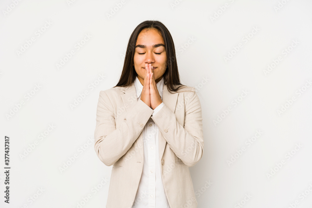 Young woman isolated on a white background holding hands in pray near mouth, feels confident. Young woman isolated on a white background holding hands in pray near mouth, feels confident.