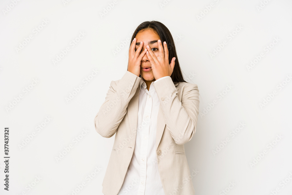 Young woman isolated on a white background blink through fingers frightened and nervous. Young woman isolated on a white background blink through fingers frightened and nervous.
