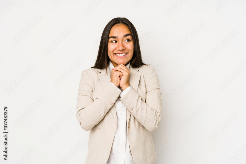 Young woman isolated on a white background keeps hands under chin, is looking happily aside. Young woman isolated on a white background keeps hands under chin, is looking happily aside.