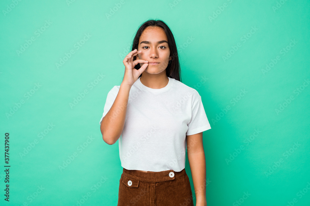 Young mixed race indian woman isolated with fingers on lips keeping a secret. Young mixed race indian woman isolated with fingers on lips keeping a secret.