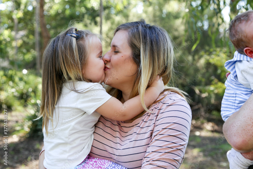 Mother and daughter cuddling and kissing