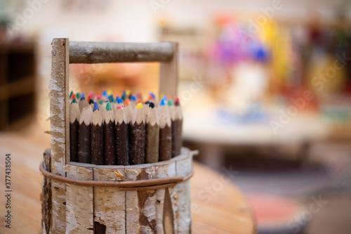 Wooden pencil holder with coloured pencils photo