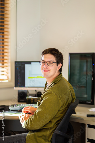 Young male uni student studying on computer at desk