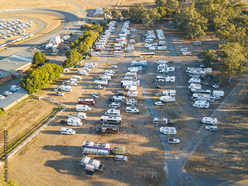 Aerial view of lots of motorhomes parked on rows on a reserve