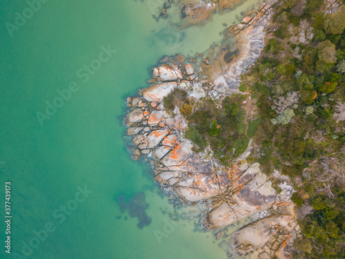 Looking down on a rocky outcrop in calm turquoise saltwater