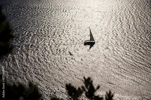 Canvas Print silhouette sailing boat view on the shimmering sea