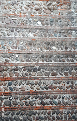 Ancient wall of stone and brick, lined with different structure and sequence. For the whole background of the photo