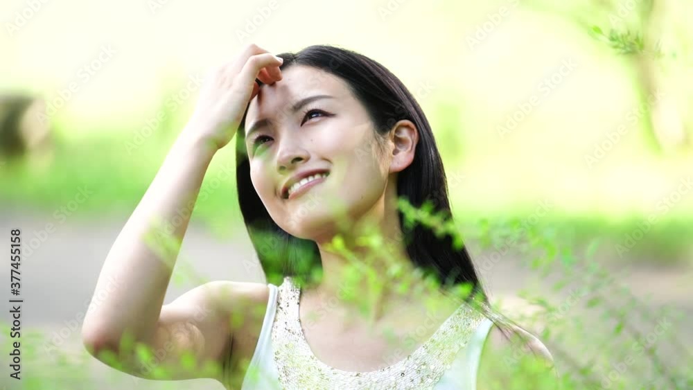 微笑む 若い女性 夏の公園 イメージ スローモーション 微笑む 若い女性 夏の公園 イメージ スローモーション