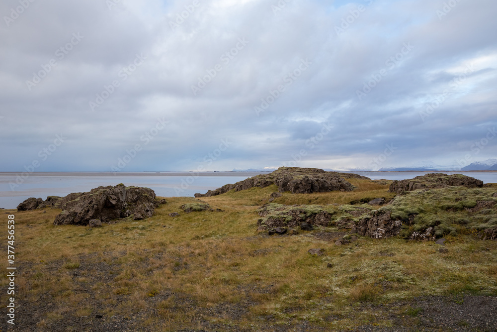 Icelandic landscape with rocks green moss and clouds