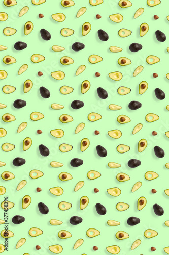 Avocado. Background made from isolated Avocado pieces on green background. Flat lay of fresh ripe avocados and avacado pieces.