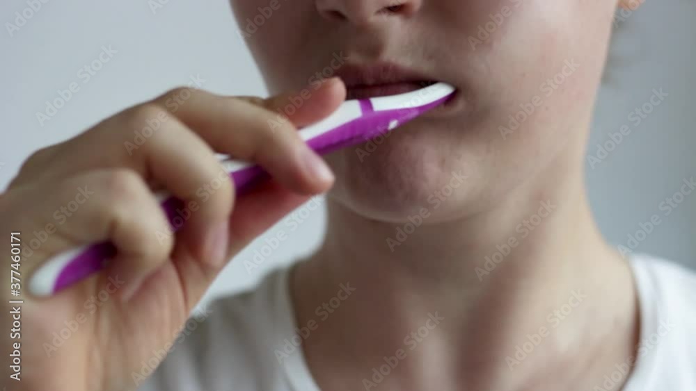 The girl brushes her teeth with a toothbrush with paste close-up. The girl brushes her teeth with a toothbrush with paste close-up.