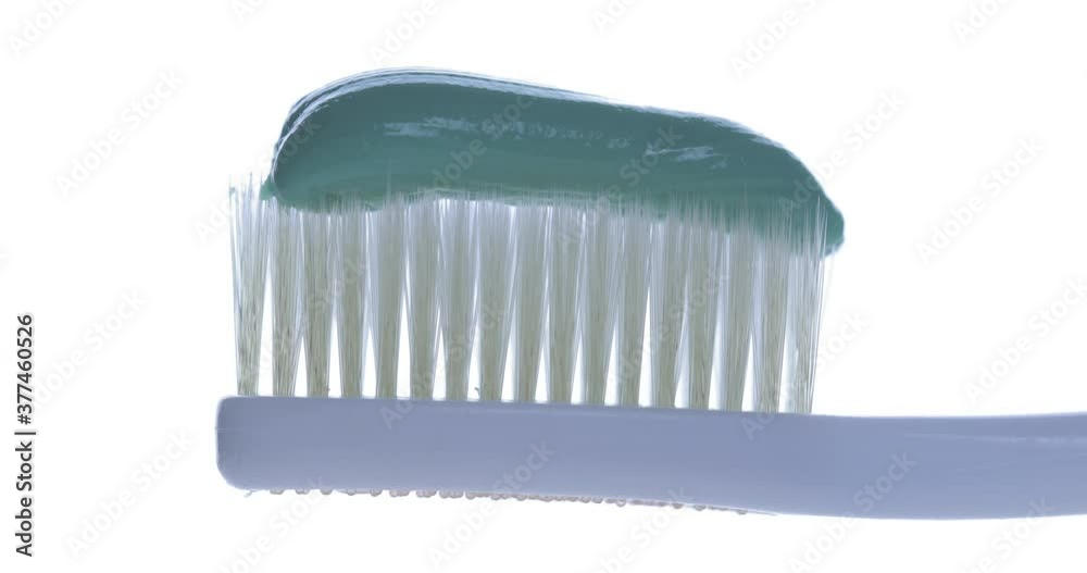 Toothpaste is applied to a toothbrush. Close up shot Toothpaste is applied to a toothbrush. Close up shot