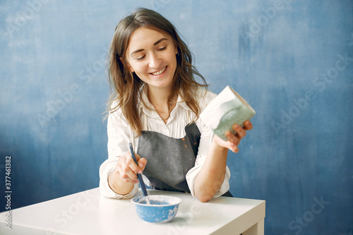 Woman in a pottery. Master paint a dishes. Artist works with a clay. Ceramics theme. photo