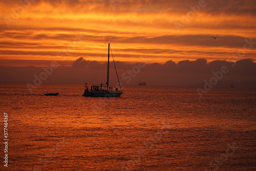 Silhouette of a sea yacht against the background of a red sunset on the sea