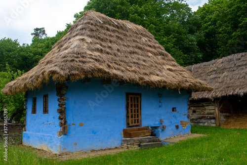 peasant house with thatched roof and tile built of clay and brick