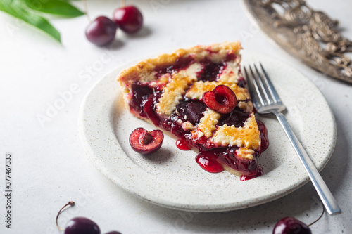 piece of Delicious homemade classic cherry pie with a flaky crust on white background