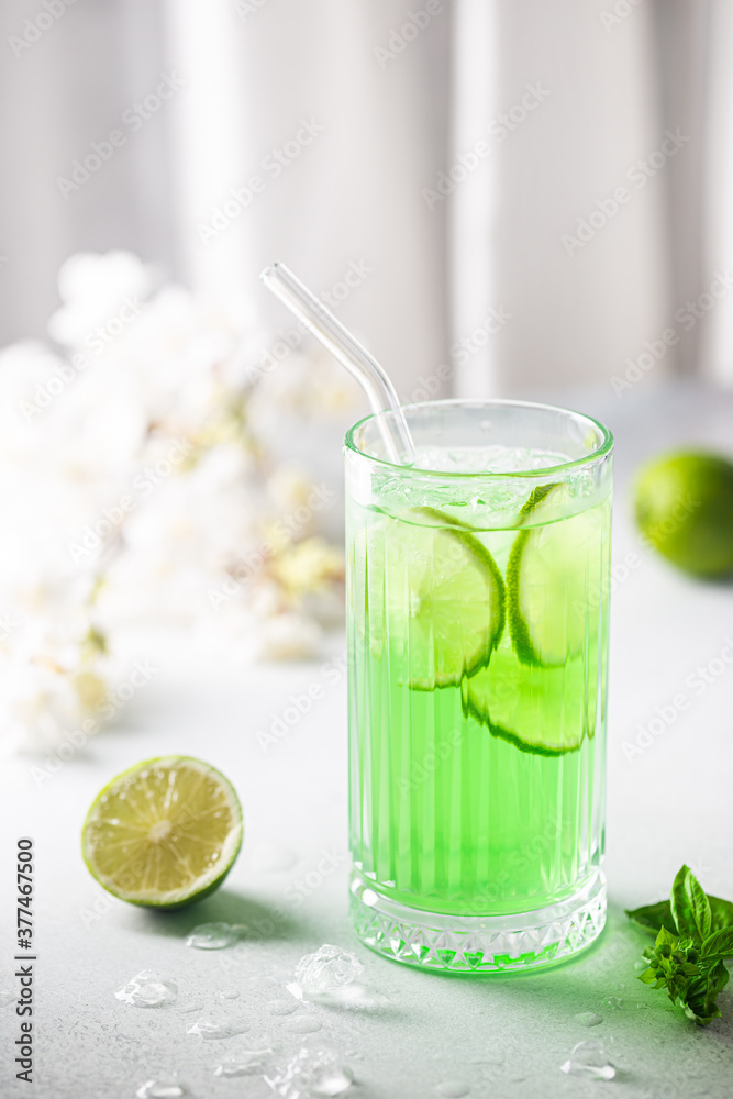 Summer green drink, lemonade with lime, basil and ice in a glass