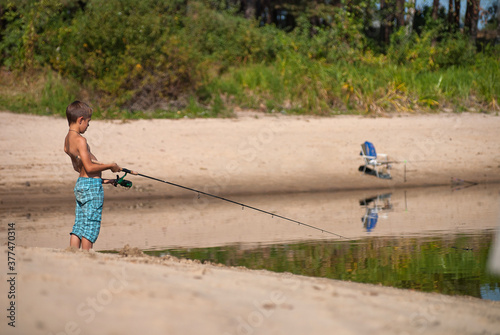 child fishing on the Teteriv river beach, Ukraine photo