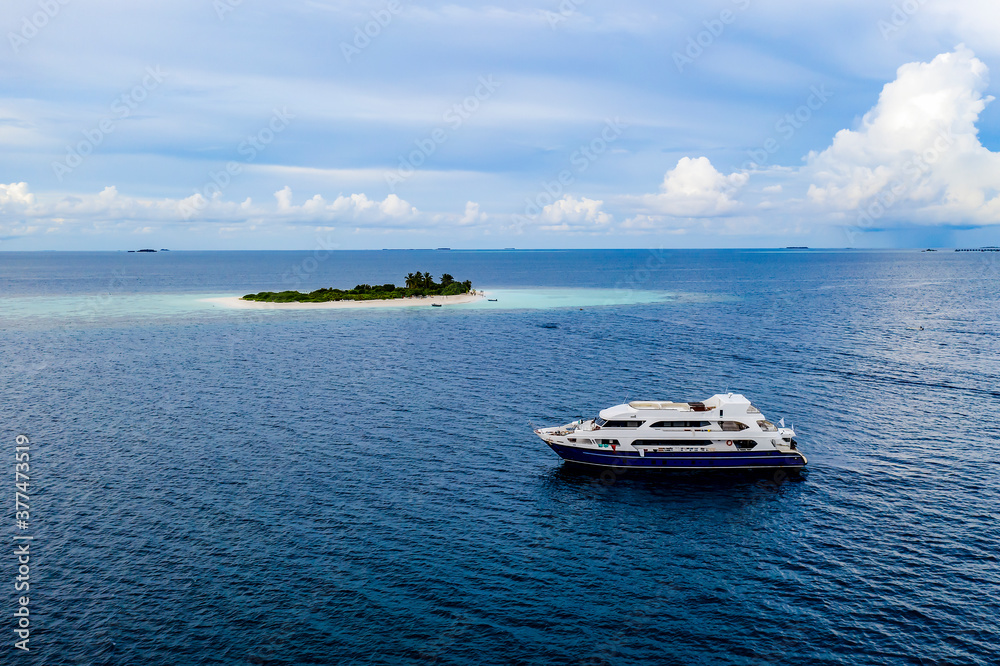Aerial view of a tourist ship and small Maldives island in the Indian ocean