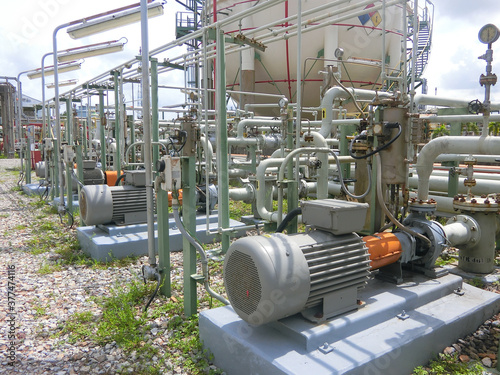 several water pumps with large electric motors and background industrial