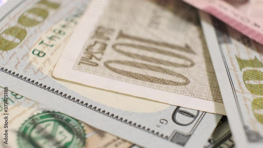 Group of American Banknotes of 100 Dollars and Georgian Lari on Rotating Table. Closeup, Shallow Depth of Field.