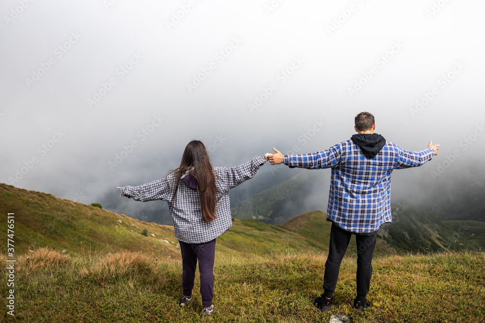 couple enjoying the landscape, fog in the mountains