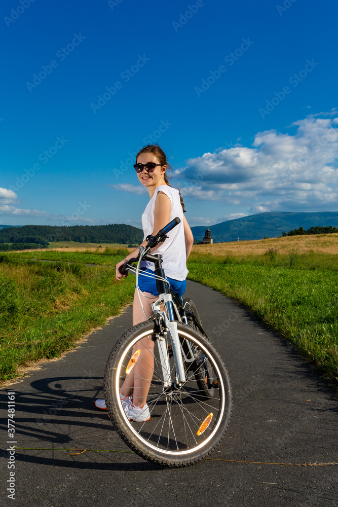 Young woman riding a bicycle on country road
Young woman riding a bicycle on country road