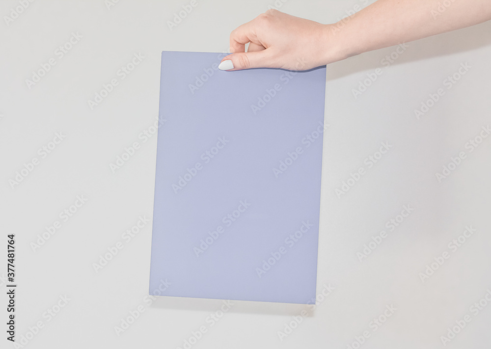 Blank colored sheet of cardboard in a womans hand on a white background with text space. A sheet for announcing and informing people. Information plate Blank colored sheet of cardboard in a womans hand on a white background with text space. A sheet for announcing and informing people. Information plate