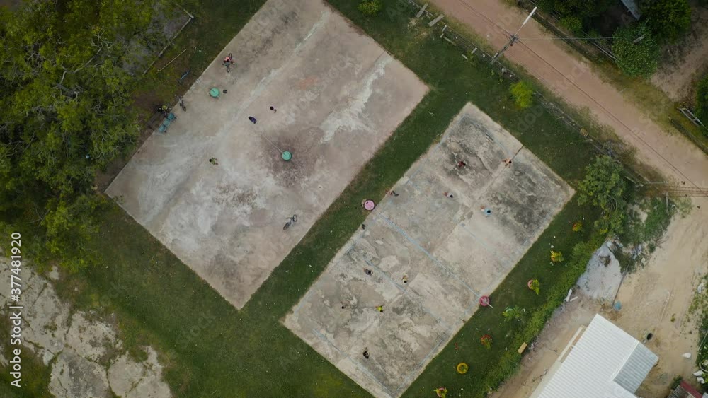 Aerial top down view of community volleyball court while youth are having fun to playing match. Vacation activities together in the community. Aerial top down view of community volleyball court while youth are having fun to playing match. Vacation activities together in the community.