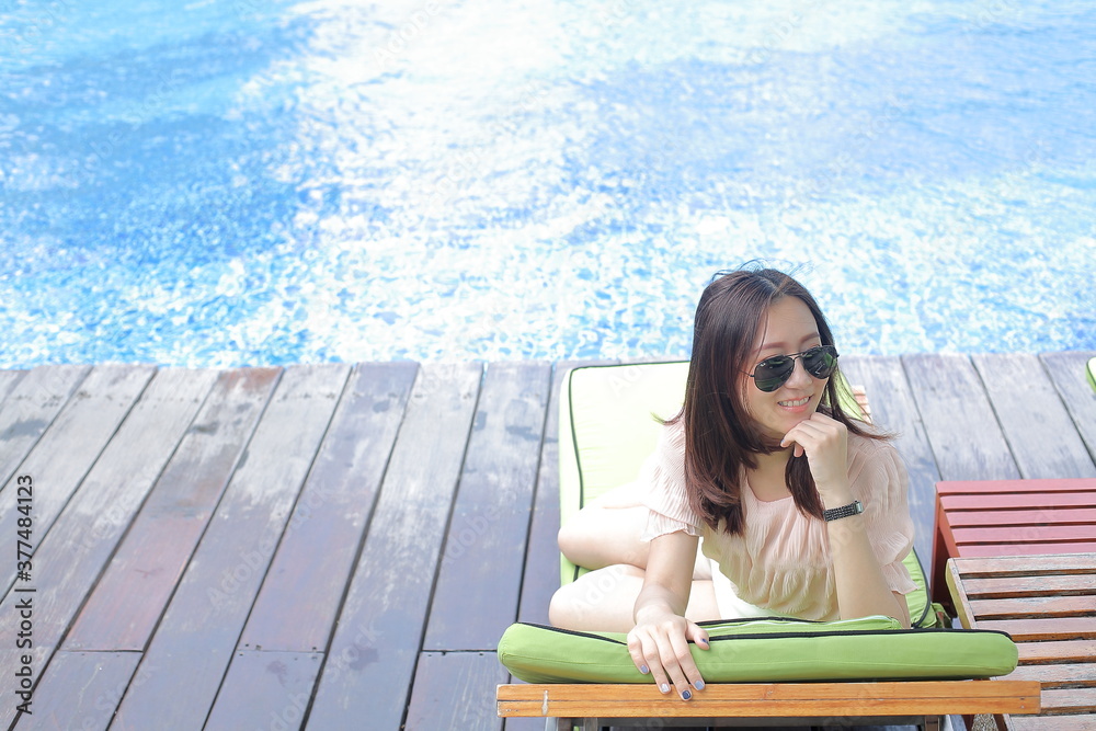 A young woman resting by the pool