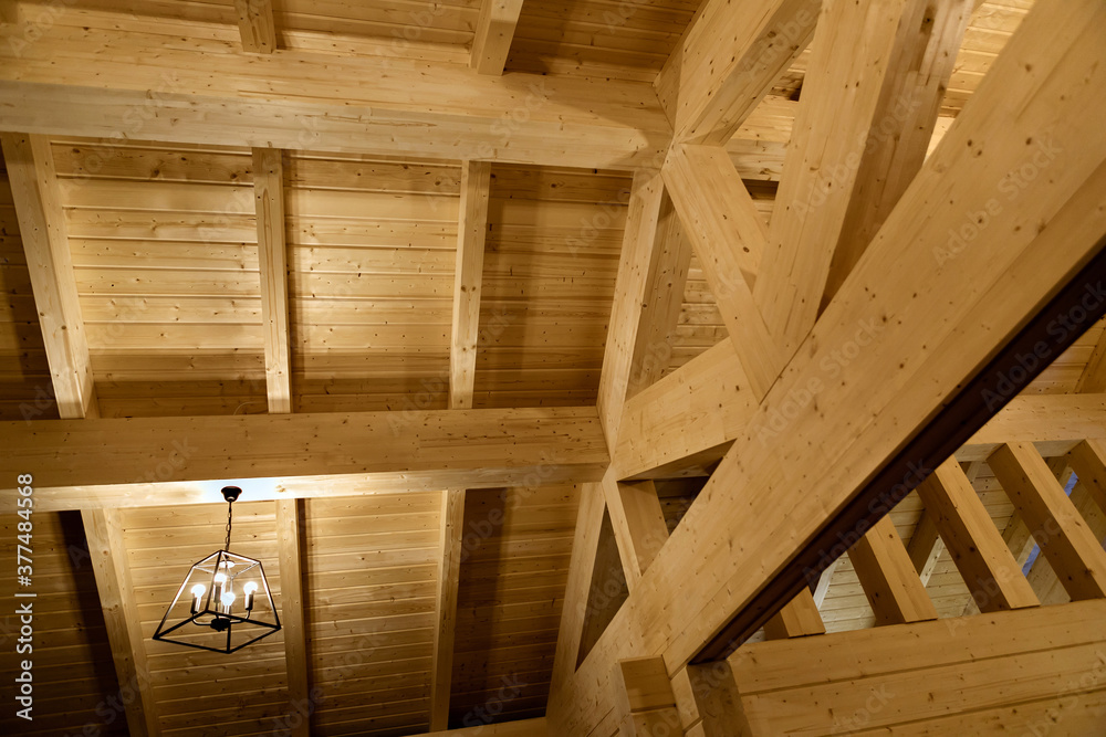Fragment of a house made of wooden beams. Roof view with chandelier. Construction of frame houses from environmentally friendly materials Fragment of a house made of wooden beams. Roof view with chandelier. Construction of frame houses from environmentally friendly materials