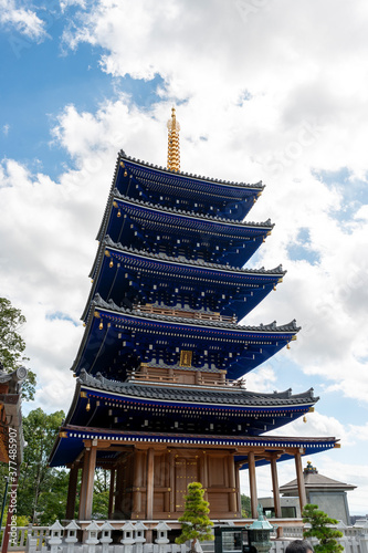 Blue colored five-storied pagoda of Nakayamadera temple in Takarazuka city, Hyogo, Japan.  Translation: two Chinese characters on the plate mean 